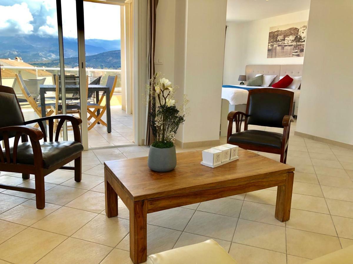 Suite con cama grande, sofá cama, terraza y vistas al mar